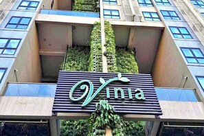 Ein Gebäude mit einem Schild, auf dem 'Vinia' steht, und einer vertikalen Grünanlage.