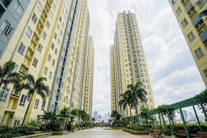 A high-rise residential building with multiple balconies, surrounded by greenery and a clear sky. - Victoria Sports Tower - Cozy Ambiance Condo Unit (Quezon City)