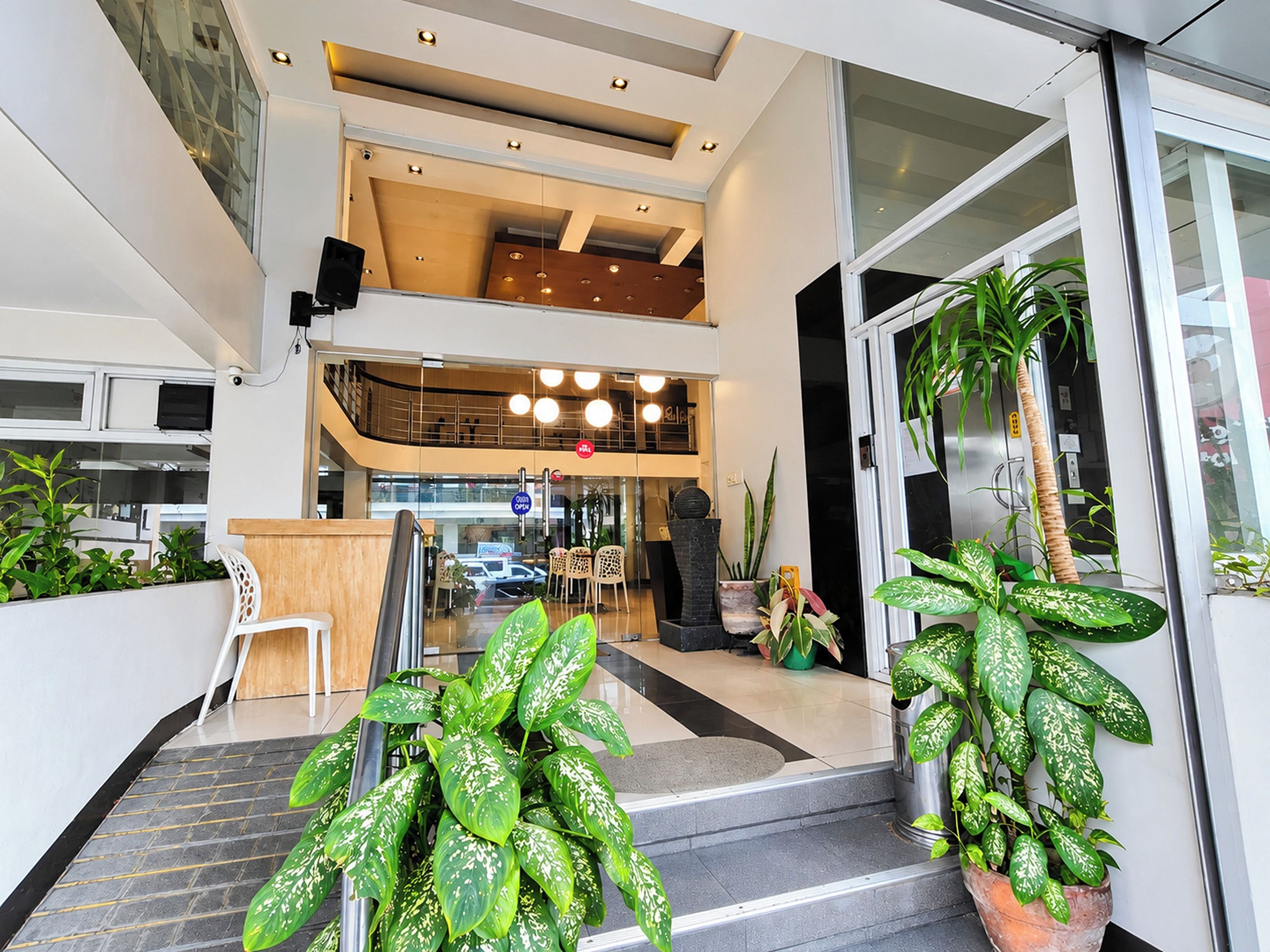 Un edificio moderno con recepción, zona de estar y plantas en macetas.