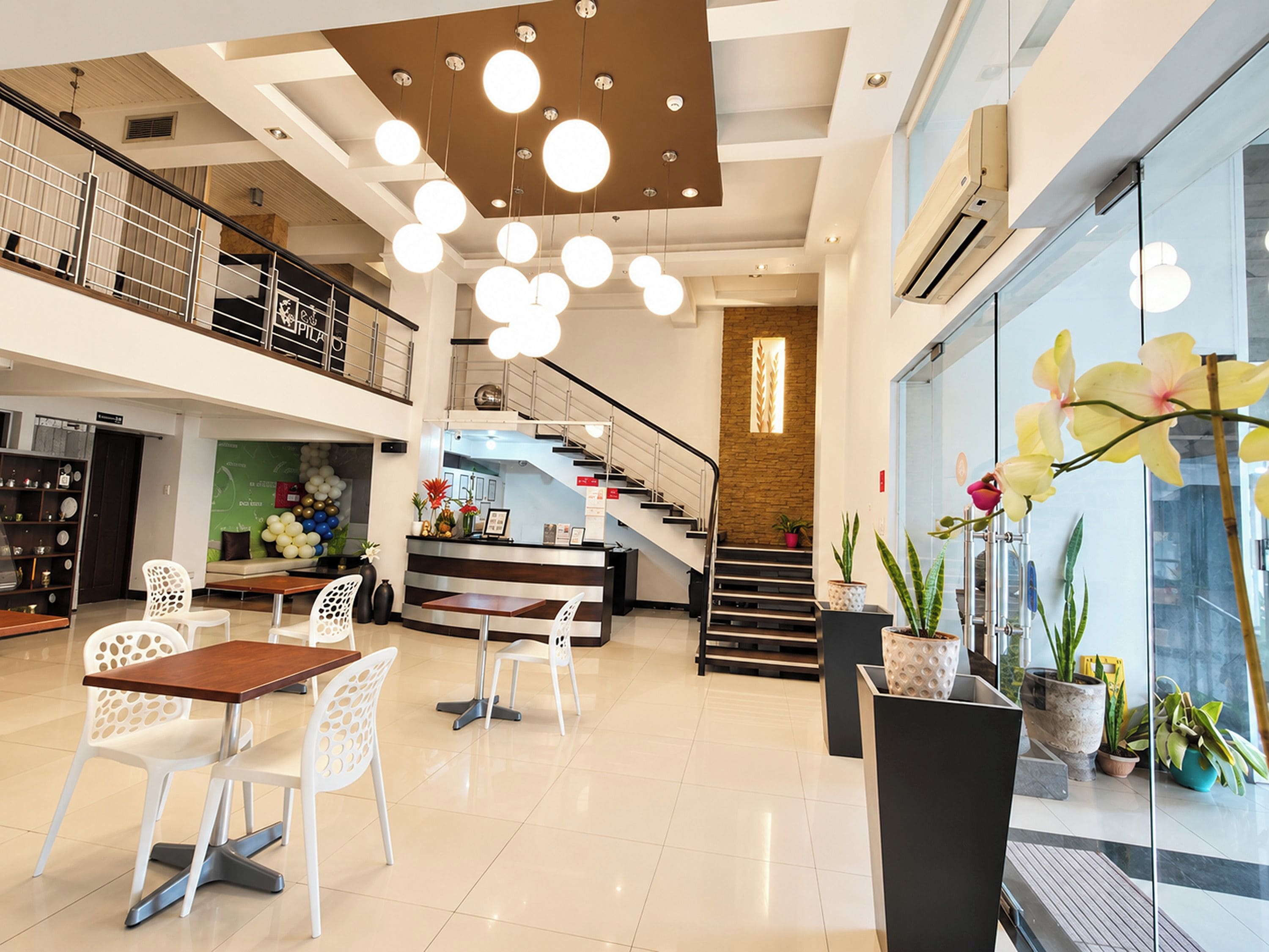 A spacious lobby with a staircase, a reception desk, and seating area.