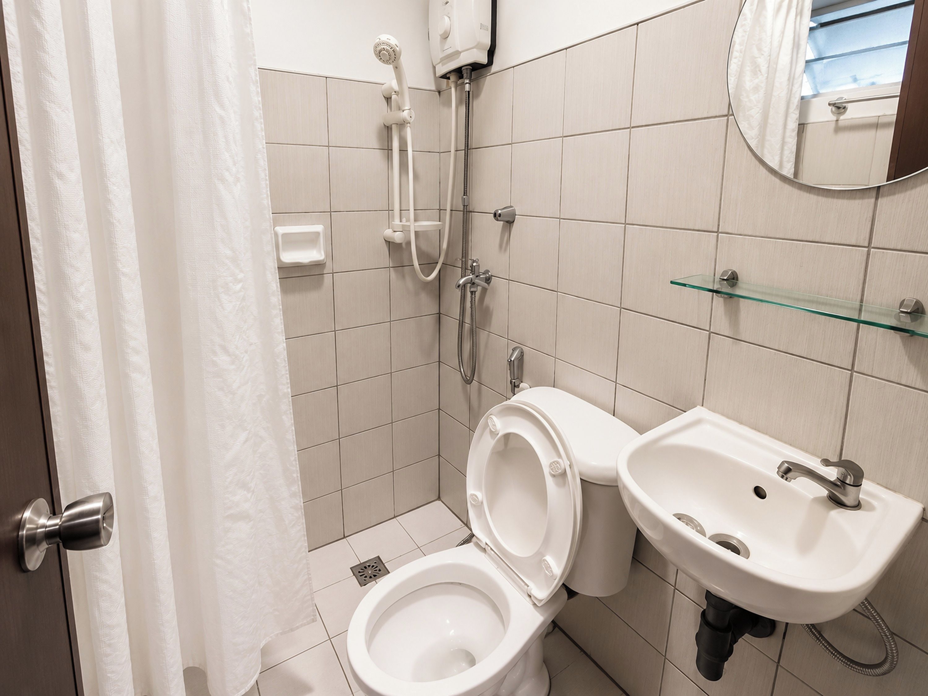 Un baño con inodoro, ducha y lavabo.