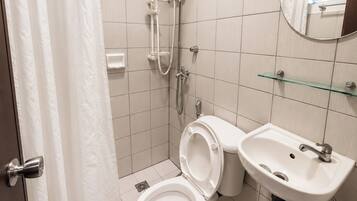 Un baño con inodoro, ducha y lavabo.