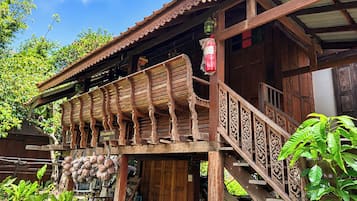 Una estructura de madera tradicional con un balcón y una escalera.
