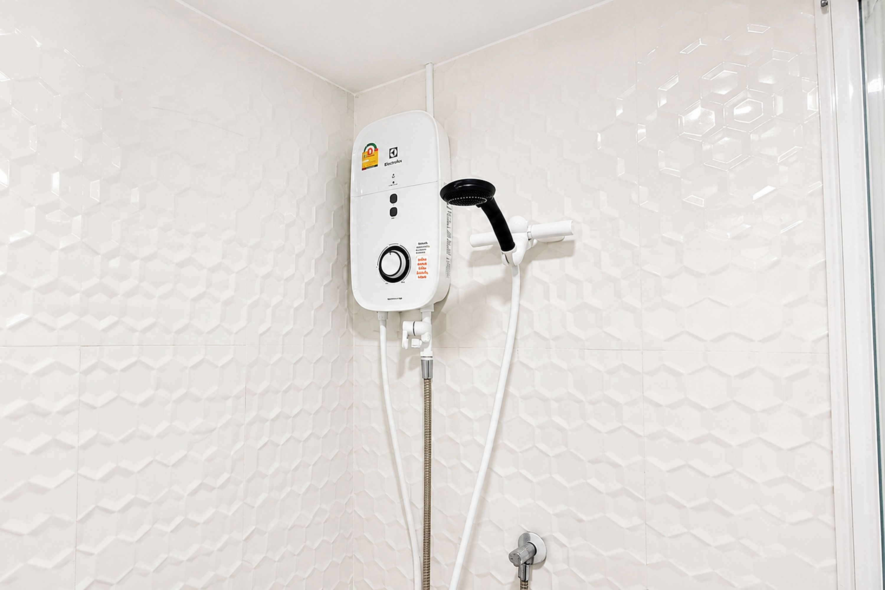 A shower unit with a control panel, a handheld showerhead, and a flexible hose.
