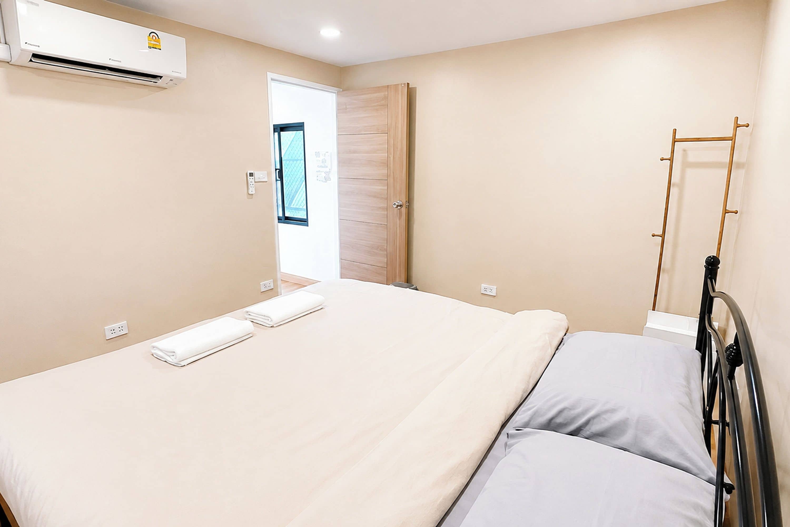 Un dormitorio con cama, ventana y equipo de aire acondicionado.