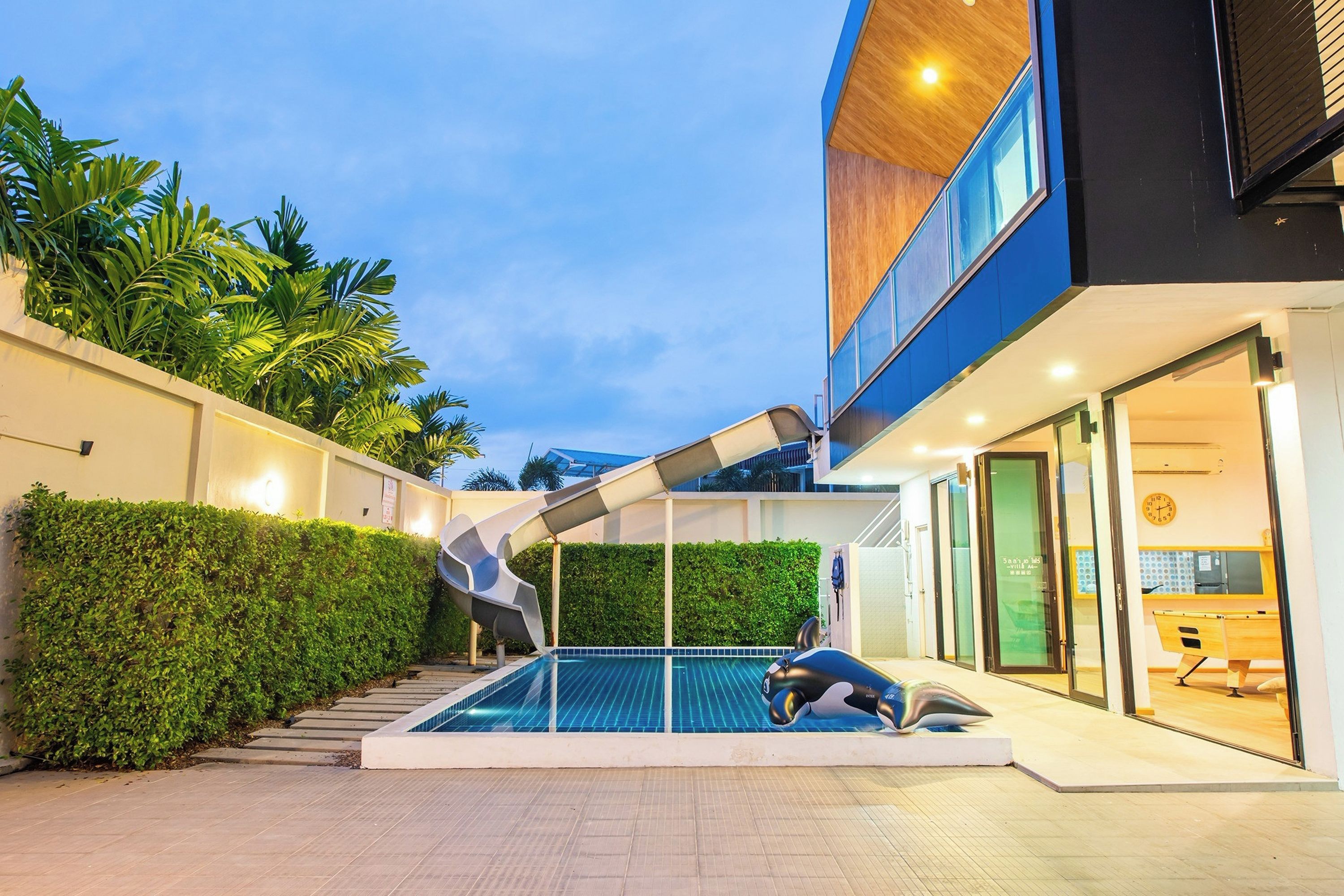 A modern building with a pool, a slide, and a staircase leading to the upper level.