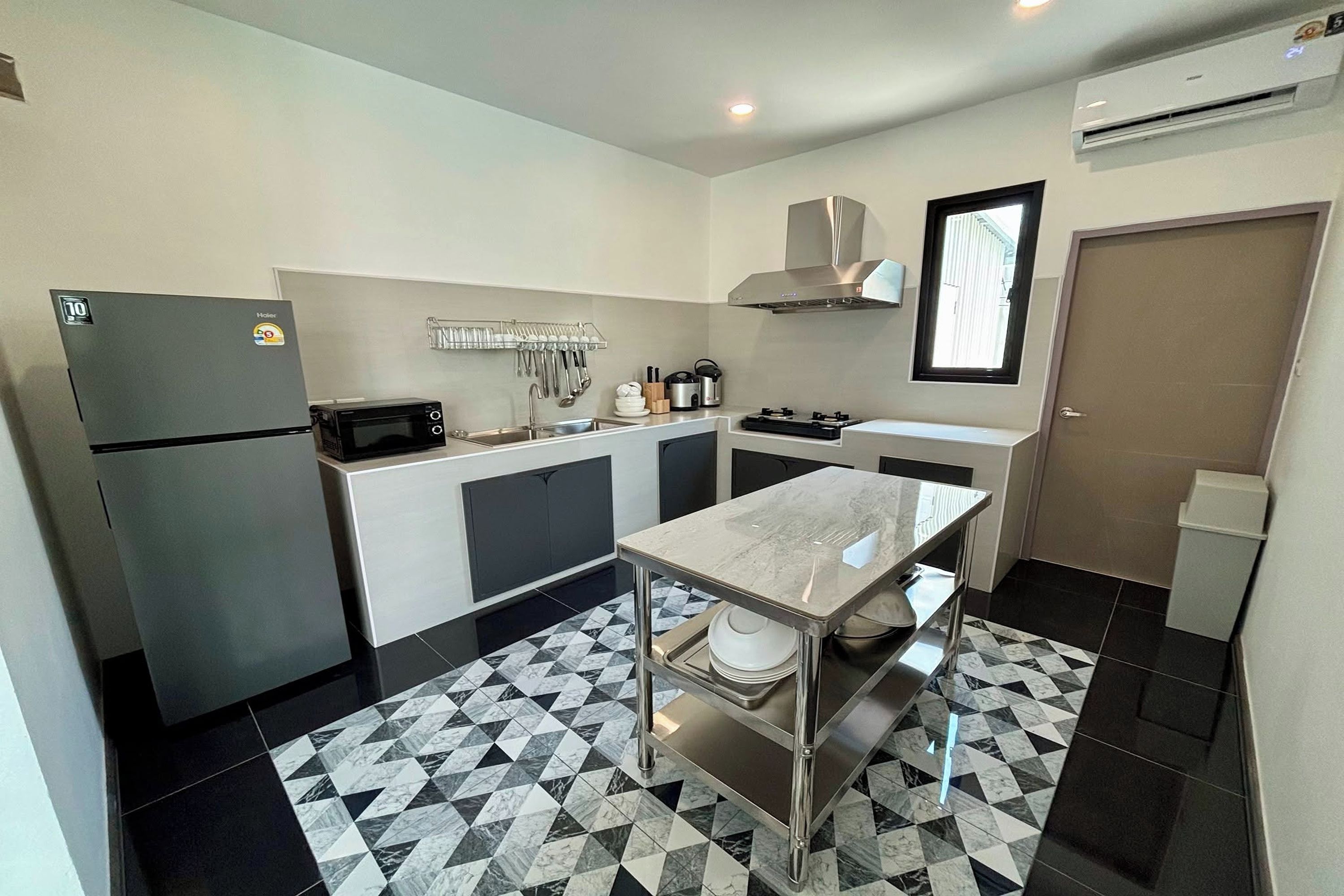Una cocina compacta con refrigerador, microondas, fregadero y estufa.