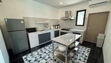 Una cocina compacta con refrigerador, microondas, fregadero y estufa.