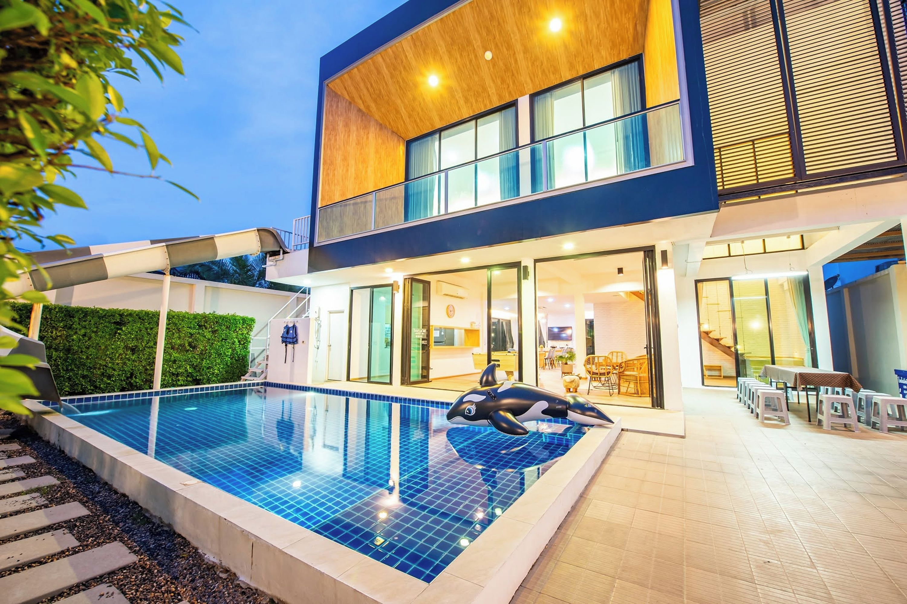 Una casa moderna de dos pisos con piscina y zona de estar al aire libre.