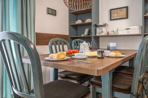 A dining area with a wooden table, chairs, and a variety of breakfast items. - 50006 House Deichkieker (Harlesiel)