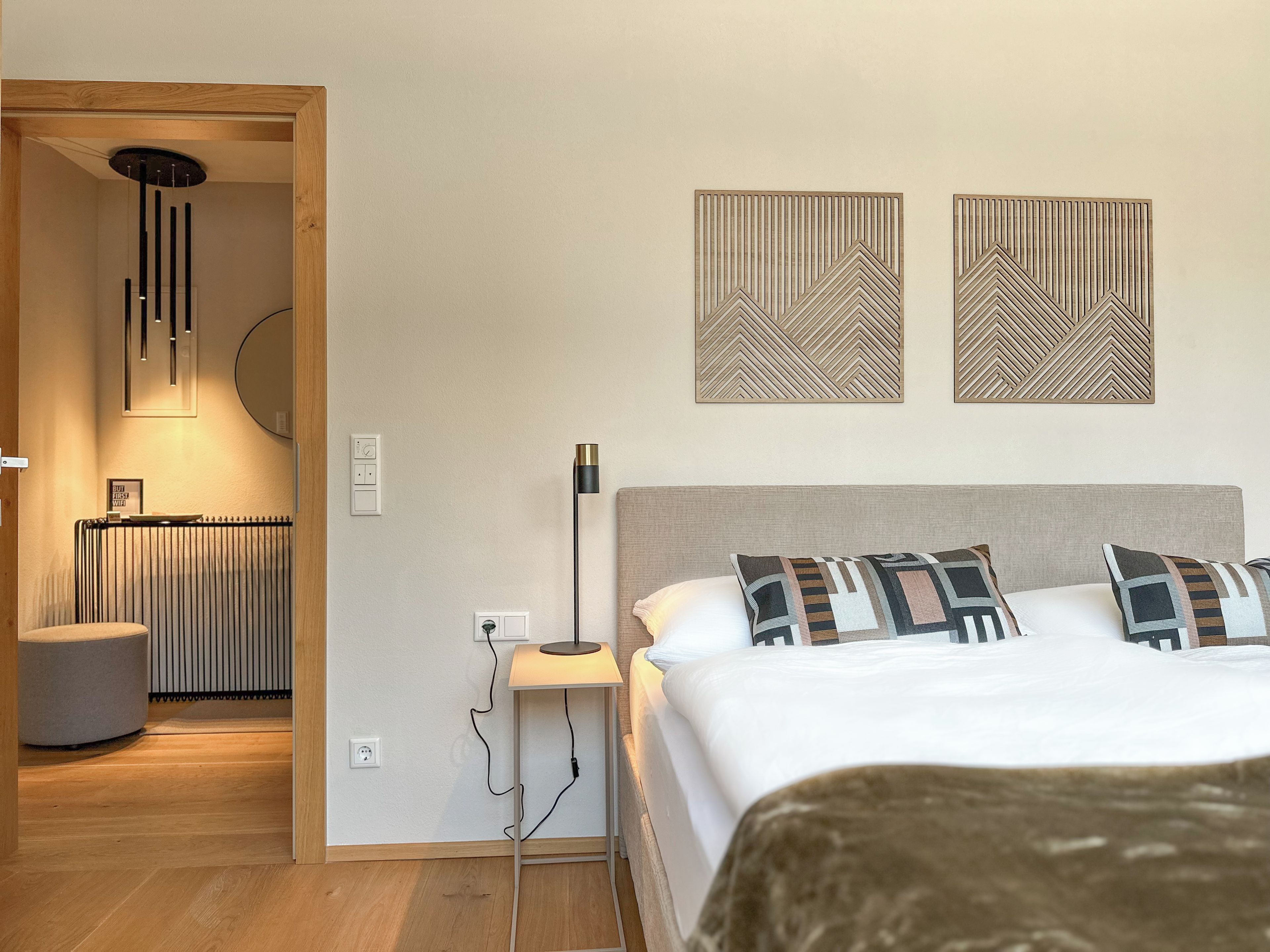 A modern bedroom with a bed, bedside lamp, and a radiator.