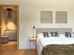 A modern bedroom with a bed, bedside lamp, and a radiator.