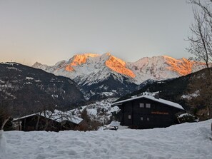 Eine verschneite Berglandschaft mit einer Holzhütte im Vordergrund, auf der 'mon blanc noir' steht.
