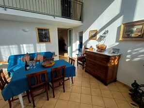 Ein Essbereich mit einem Tisch für vier Personen, einer blauen Tischdecke und Holzsesseln.