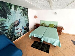 Ein Schlafzimmer mit einem Bett, einem Nachttisch, einer Lampe und einer Wandmalerei.