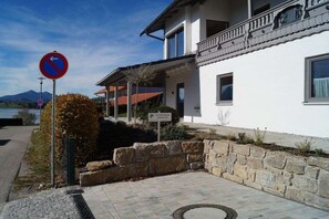 A building with a stone retaining wall, a paved entrance, and a no parking sign. - Holiday apartment with 1 bedroom (Hopfen am See)