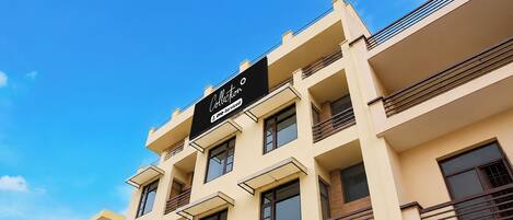 A multi-story building with a sign reading 'Collection OYO-Serviced'.
