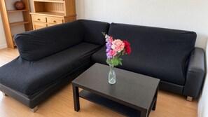 Un divano componibile con un vaso di fiori su un tavolino coordinato.