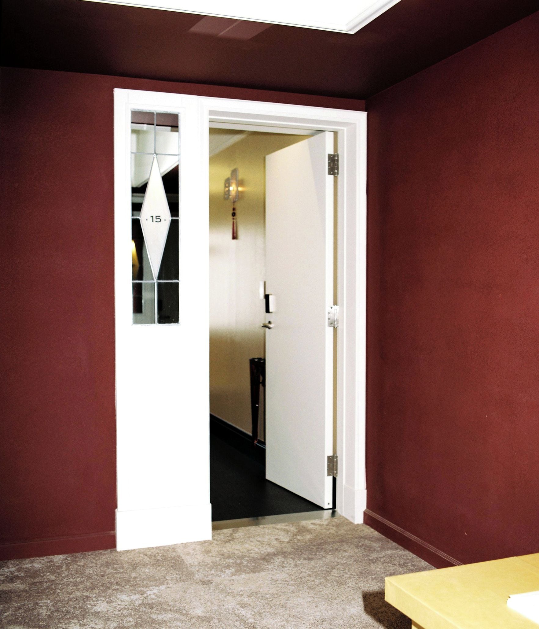 A room with a closed door, a carpeted floor, and a small table.