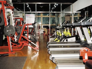 A gym with exercise equipment, including treadmills and weight machines, and a sign with information. - The Magpie Hotel (Seoul)