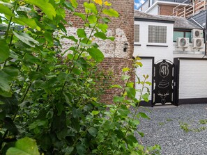 A brick wall with a white door and a black gate with a number 41 emblem. - Modern Elegance at Residence 41 - Heart of Bastogne (Bastogne)