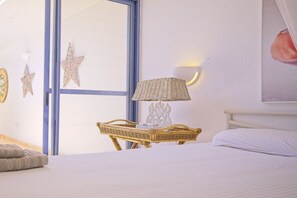 A bedroom with a bed, a bedside lamp, and decorative stars on the wall.