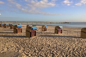 Una playa con hileras de cabañas de playa numeradas.
