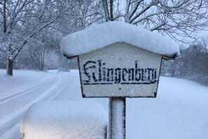 Un panneau enneigé portant l’inscription « Slingendorf », situé dans un cadre rural.