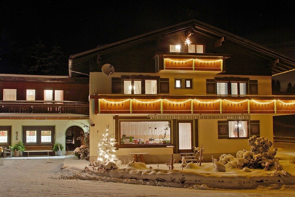 A two-story building with a balcony, a dining area, and a Christmas tree.