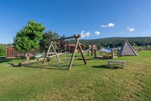 An outdoor playground with swings, a slide, and a picnic table. - on the farm Trout Riding Stable (Neureichenau)