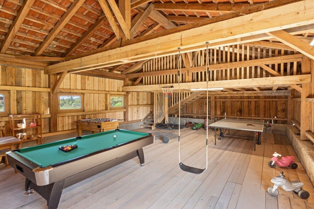 Ein Holzinterieur mit Billardtisch, Pongtisch und Kinderspielzeug.