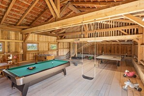 A wooden interior with a pool table, ping pong table, and children's toys. - on the farm Trout Riding Stable (Neureichenau)