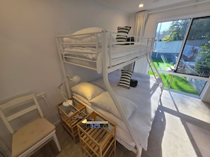 Habitación con literas, un escritorio y vistas al exterior.