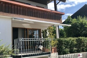 A residential building with a balcony, a window, and a door. - Holiday apartment with 1 bedroom (Hopfen am See)