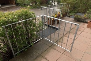 A metal fence structure with a metal staircase leading to a raised platform. - Holiday apartment with 1 bedroom (Hopfen am See)