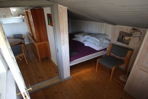 Ein kleines Schlafzimmer mit einem Einzelbett, einem kleinen Tisch und einem Stuhl.