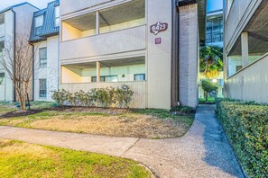 Un bâtiment moderne doté d’un toit plat, d’une enseigne indiquant l’adresse, et d’un chemin menant à l’entrée.