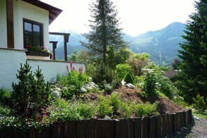 A house with a garden in front, a wooden fence, and mountains in the background. - Alpenrose Punzenlehen (Schönau am Königssee)