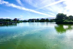 A calm lake with a bridge and buildings in the background. - Bungalow with 2 bedrooms (Wenningstedt-Braderup)