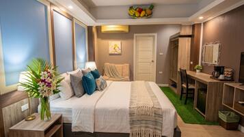 A modern bedroom with a bed, bedside table, lamp, and a small desk area with a mirror.