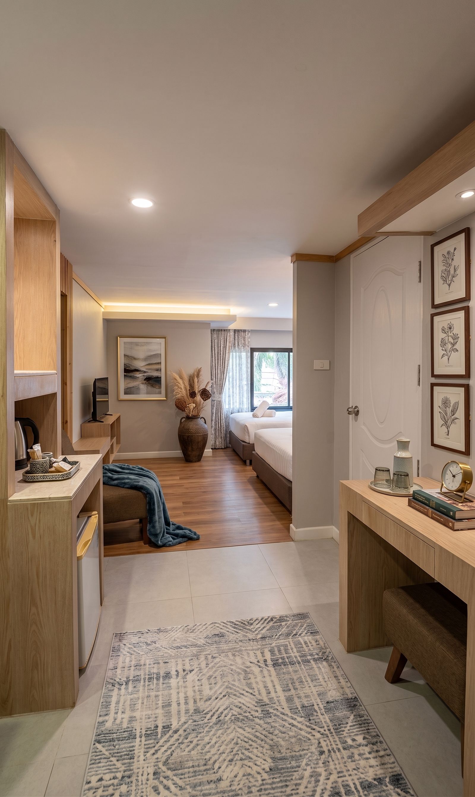 A modern bedroom with a bed, bedside tables, a desk, and a large window.