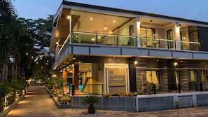 Un hotel de dos pisos con balcón, mobiliario exterior y un letrero que dice 'The Golden Pattaya Hotel & Resort'.