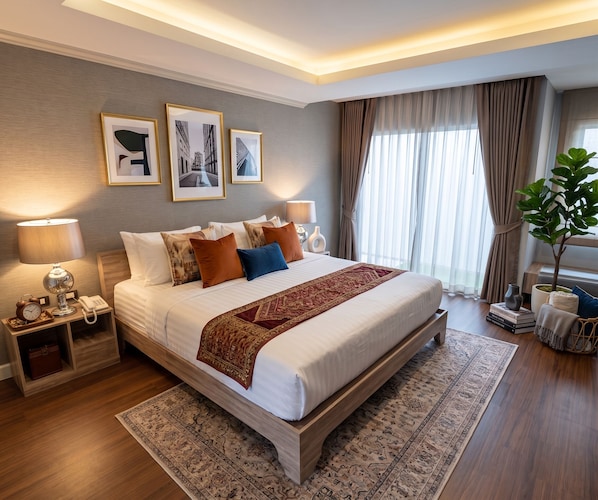 A modern hotel room with a large bed, bedside lamps, a nightstand, a potted plant, and framed pictures on the wall. - Tamnan Pool Resort Pattaya (Pattaya)