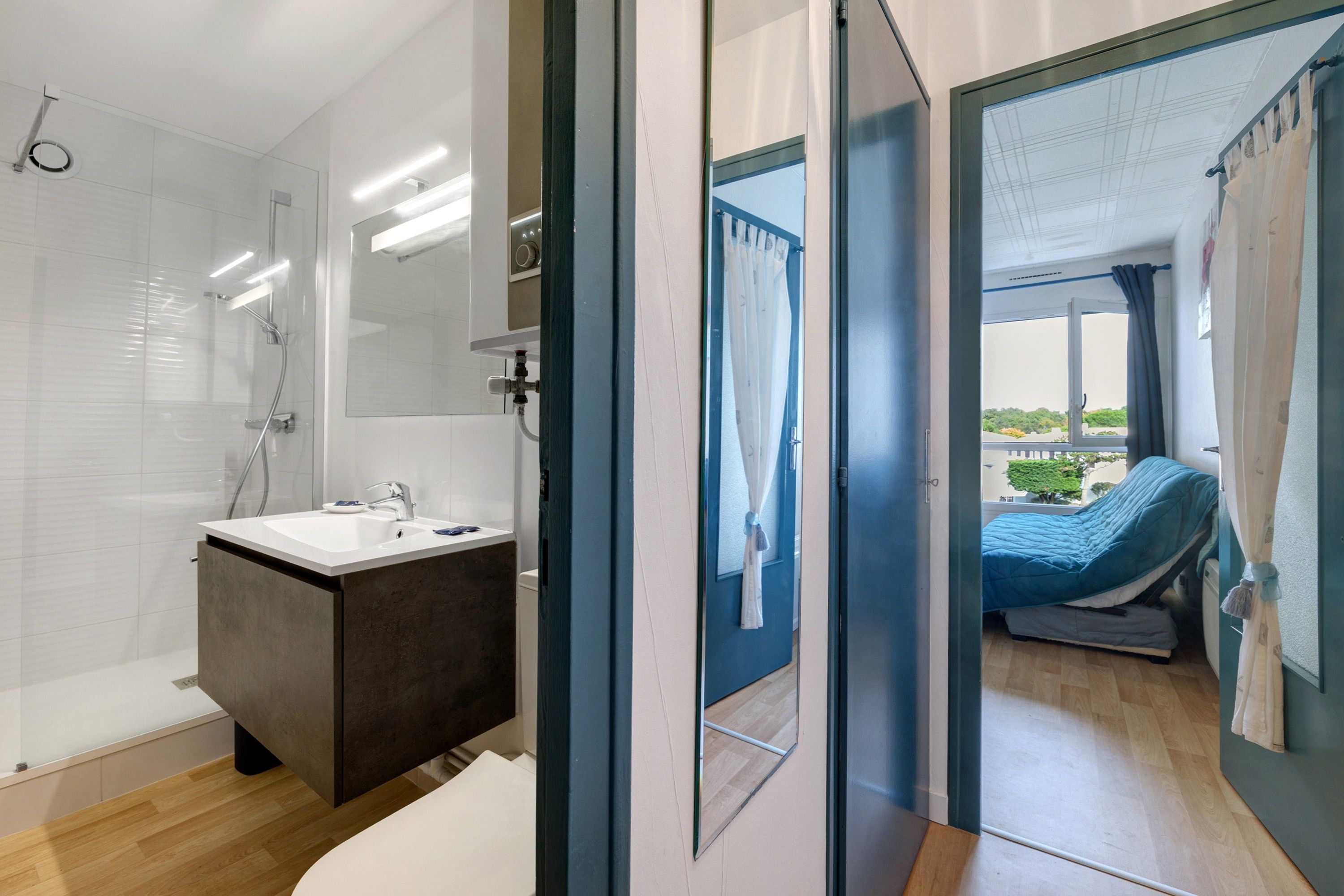 Une salle de bain moderne équipée d’une douche, d’un lavabo et d’un miroir.