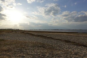 A beach with a clear sky and distant trees. - Holiday home in Hooksiel with swimming pool (Hooksiel)
