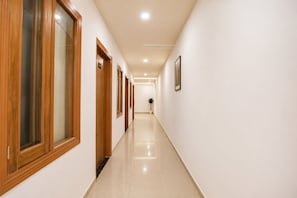 A long, narrow hallway with wooden doors and a tiled floor.