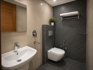 A modern bathroom with a sink, toilet, and shower.