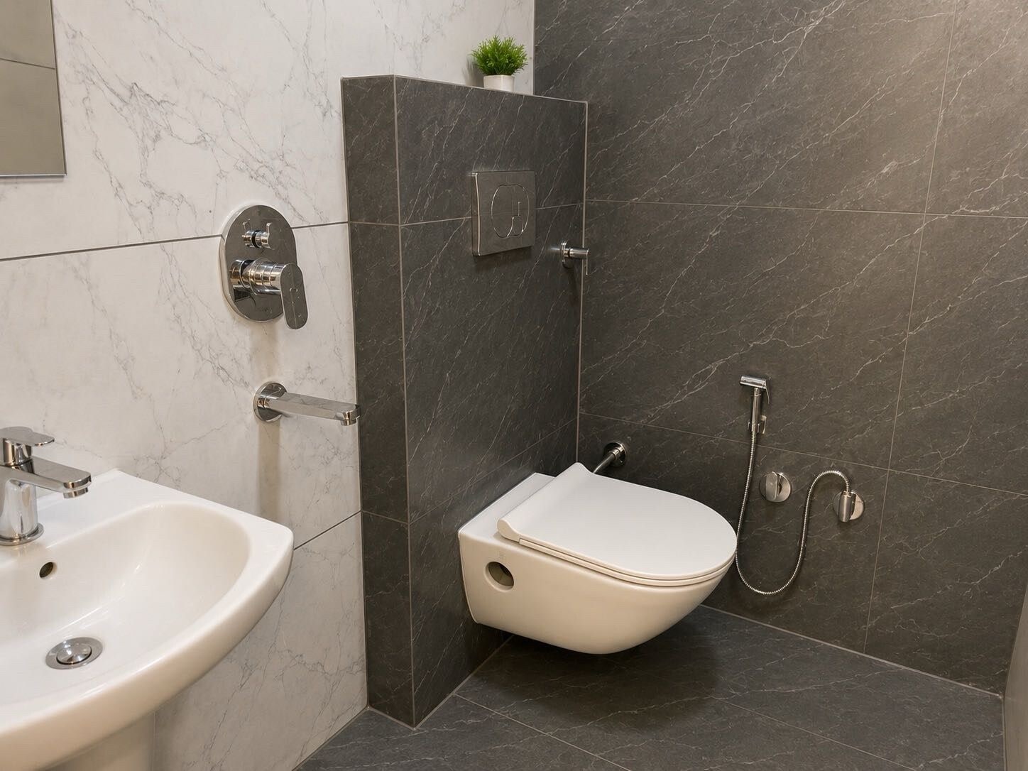 Un baño con lavamanos blanco, inodoro y zona de ducha.