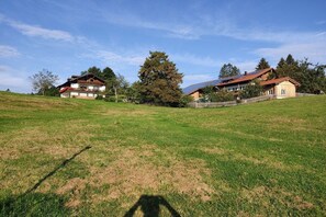 A rural property with two houses on a grassy hill, a wooden fence, and a large tree. - Ferienhof Waibel - Oberallgäu (Waltenhofen)