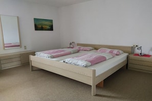 Ein Schlafzimmer mit einem Doppelbett, Nachttischen, einem Spiegel und einem Bild an der Wand.